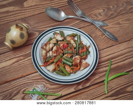 A Plate With Freshly Prepared Vegetables Beans, Wetter, Pepper And Onions, Chicken Pieces On A Woode