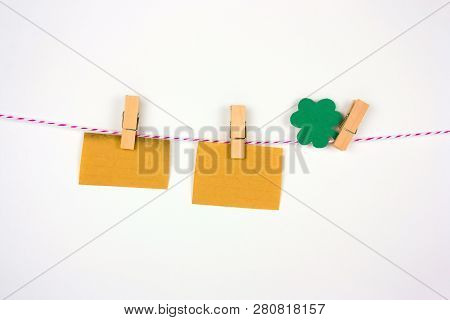 Old Vintage Paper Mock Up And Shamrock Paper Cut Leaves On Clothespin On White Bakground