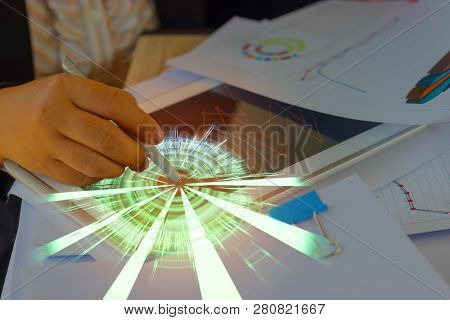 Hand Of Business Analyst Holding Pen Is Analyzing Graphs About Marketing On Tablet. Unfinished Paper