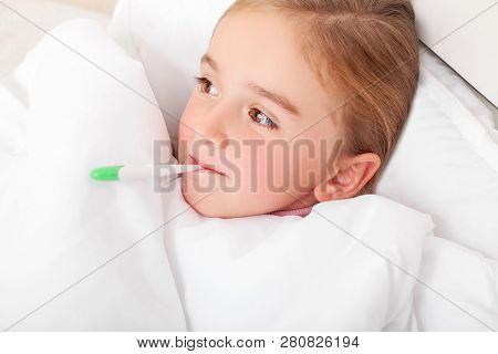 Sick Girl Resting In Bed With Fever Meassuring Temperature With