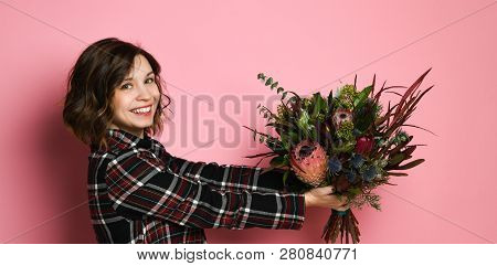 Side View Profile Of Attractive Young Woman In A Dark Checkered Dresst Holding Bouquet Of Flowers An