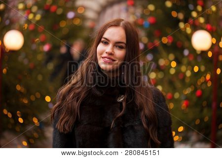 Portrait of a Young beautiful brunette woman in mink fur coat, posing in winter Red Square in central Moscow
