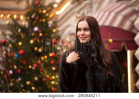 Portrait of a Young beautiful brunette woman in mink fur coat, posing in winter Red Square in central Moscow