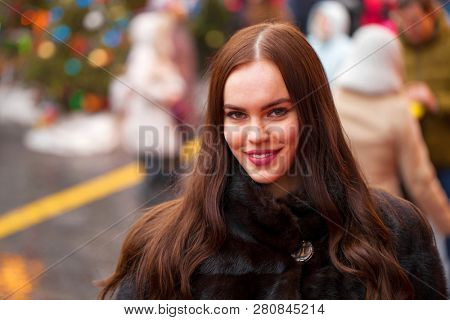 Portrait of a Young beautiful brunette woman in mink fur coat, posing in winter Red Square in central Moscow