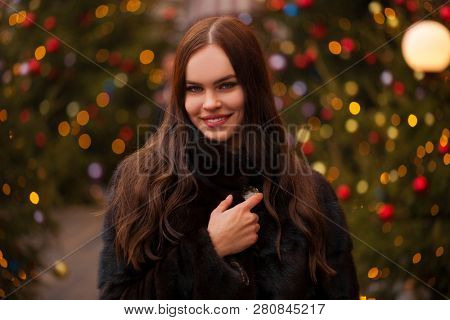 Portrait of a Young beautiful brunette woman in mink fur coat, posing in winter Red Square in central Moscow