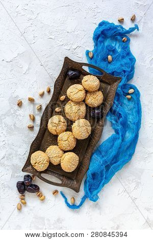 Bronze Tray With Moroccan Cookies With White Sesame Seeds On Textured White Background. Top View.