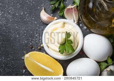 Mayonnaise Sauce And Ingredients On Black Stone Table. Top View With Copy Space.