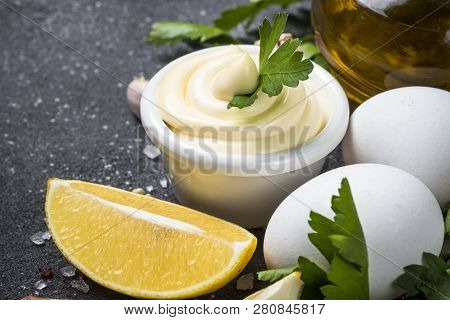 Mayonnaise Sauce And Ingredients On Black Stone Table. Close Up With Copy Space.