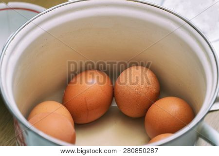Raw Chicken Eggs In A Pan In The Kitchen. Selective Focus