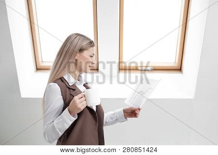 Blonde Girl In A Business Suit Works On A Computer In A White Bright Office.