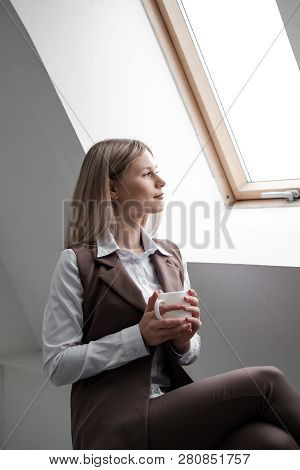 Blonde Girl In A Business Suit Works On A Computer In A White Bright Office.