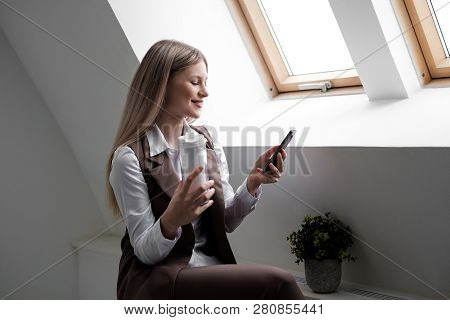 Blonde Girl In A Business Suit Works On A Computer In A White Bright Office.