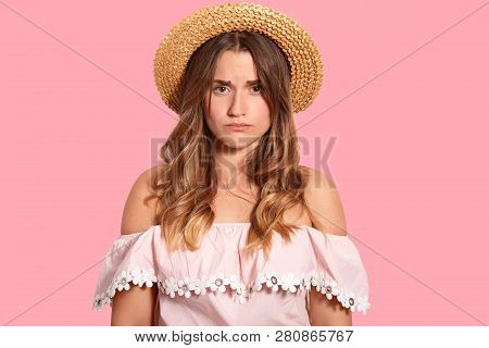 Image Of Displeased Young Woman With Sad Expression, Doesnt Like Something, Wears Headgeear And Fash