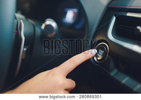 Car Driver Starting The Engine Keyless. Black. Female Hand.