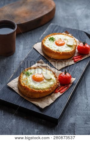 Bread With Cheese And Yolk For Breakfast On Black Cutting Board