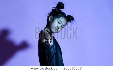 Joyfull Asian Kid Girl In Shirt And Pants With Stars And White Sneaker Stands With Her Hand Up And S