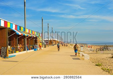 Costa Da Caparica, Lisbon, Portugal - September 17, 2018: People Walking By Seaside Promenade In The