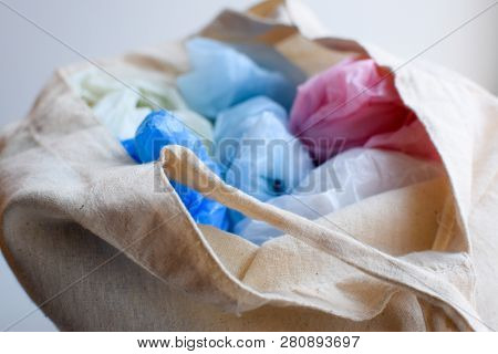 Multi-colored Blue, Red, White Plastic Bags In A Rag Cotton Bag On A White Background