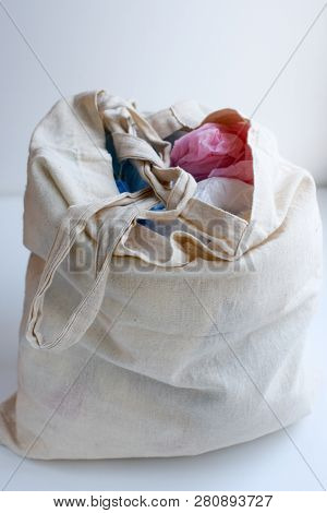Multi-colored Blue, Red, White Plastic Bags In A Rag Cotton Bag On A White Background