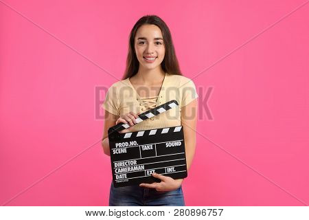 Woman With Clapperboard On Color Background. Cinema Show