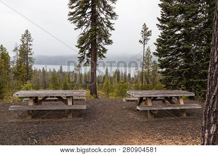 Two Wooden Picknic Tables At A Viewing Area With Diamond Lake In The Distance On A Foggy Afternoon I