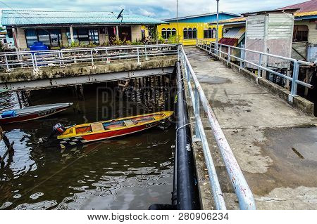 Labuan,malaysia-jan 15,2019:wooden Houses Built On Stilts On Water With Fishing Boat In Patau Patau,