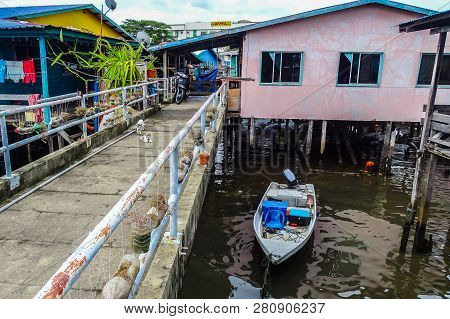 Labuan,malaysia-jan 15,2019:wooden Houses Built On Stilts On Water With Fishing Boat In Patau Patau,