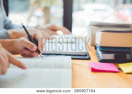 High School Or College Students Studying And Reading Together In Library