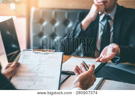 Senior Manager Reading A Resume During A Job Interview Employee Young Man Meeting Applicant And Recr
