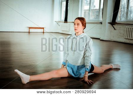 Pretty Dark-haired Teenager In Black Shorts Doing Legs-split