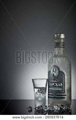 St.Petersburg, Russia - December 2018 - Bottle of cold vodka Czar's with ices and shot glass on a grey background with reflection. Premium vodka.  Produced in Russia. Original russian recipe