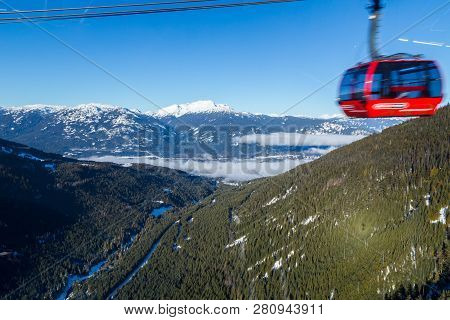 A Large Gondola Car Streaking By With The Valley In Between Whistler And Blackcomb In The Background