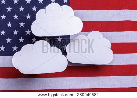 American Flag Star Spangled Banner With Three White Clouds Floating Over The Flag. Red White And Blu