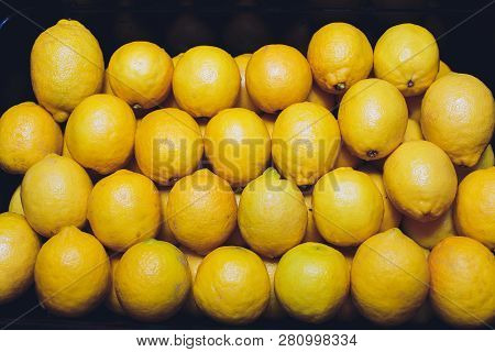 Fresh Lemons In A Wooden Box. On The Black Chalkboard.