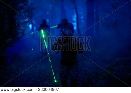 soldiers squad in action on night mission using laser sight beam lights  military team concept