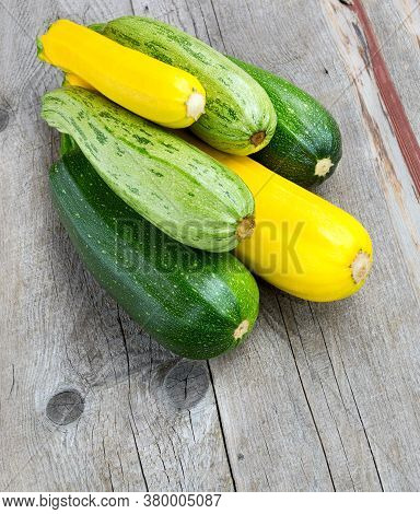 Zucchini On Wooden Background. Yellow And Green Zucchini. Vegetable Marrow Courgette Or Zucchini. Ha