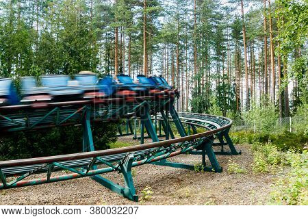 Ride Roller Coaster In Motion In Amusement Park At Summer Day