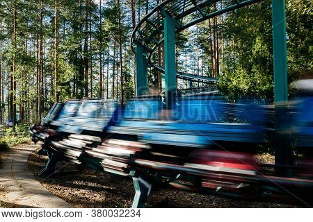 Ride Roller Coaster In Motion In Amusement Park At Summer Day