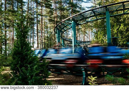 Ride Roller Coaster In Motion In Amusement Park At Summer Day