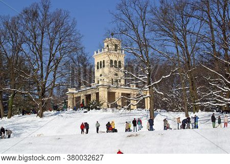 ZAGREB, CROATIA - JANUARY 12, 2014: Landscape view of a snowy hill with families with children and people sledging and having fun in snow, Park Maksimir in Zagreb, Croatia
