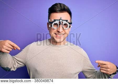 Young handsome caucasian man wearing optometrical glasses over purple background looking confident with smile on face, pointing oneself with fingers proud and happy.