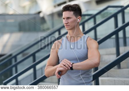 Training And Lifestyle Concept. Runner With Heart Rate Monitor Sports Smart Watch. Looking At Watch.