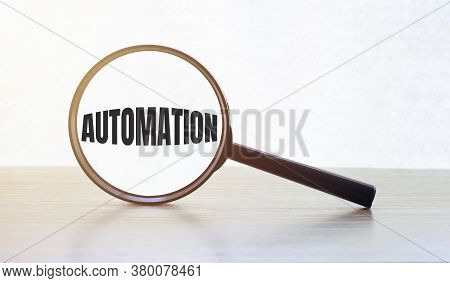 Magnifying Glass With Text Automation On Wooden Table.