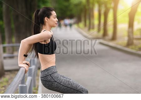 Outdoor Training. Motivated Asian Girl Exercising With Handrail In Park, Making Bodyweight Push Ups,