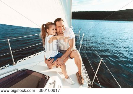 Cheerful Father And Daughter Sitting On Yacht Deck Enjoying Sailing During Sea Boat Tour Oudoor. Cop