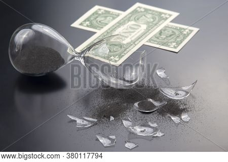Broken Hourglass On The Background Of Banknotes. Loss Of Time And Finances. End Of Earning Opportuni
