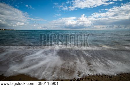 Seawaves Splashing Onto The Sandy Coast With Pebbles And Blue Cloudy Sky. Melanda Coast , Pissouri C
