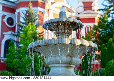 Marble Fountain With Water Cascades . Fountain In The Church Yard