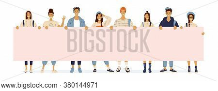 Students Hold A Poster With Copy Space. Young Guys And Girls Are Holding A Large Sheet Of Paper With