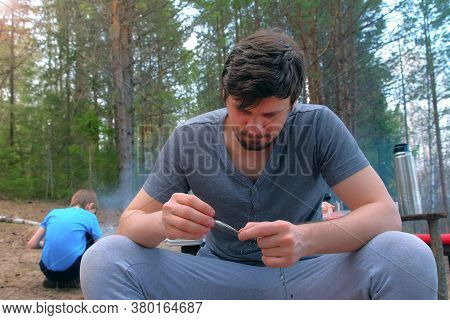 Man Untangles A Fishing Line And Hooks Preparing To Fishing On Nature. Fishing Equipment And Tools F